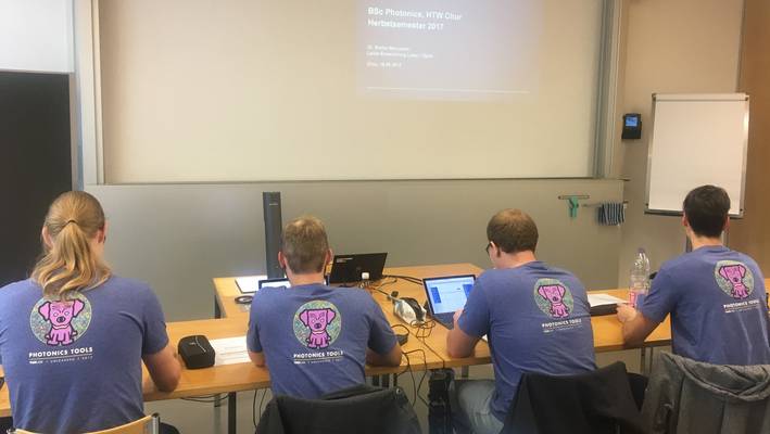 Studierende des Bachelorstudiums Photonics tragen T-Shirts einer Partnerfirma.