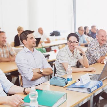 Teilnehmende sitzen im Unterrichtsraum