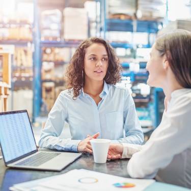 Businesswomen discussing over available warehouse stock