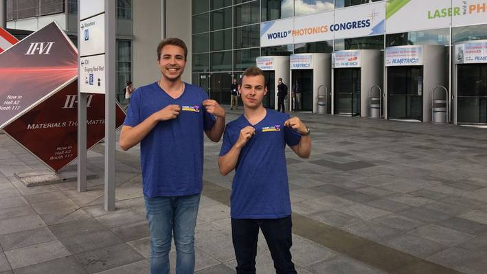 Die Studierenden posieren vor dem Eingang der Laserworldmesse in München.