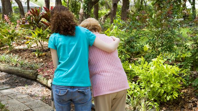 Junge Frau hilft einer Seniorin beim gehen
