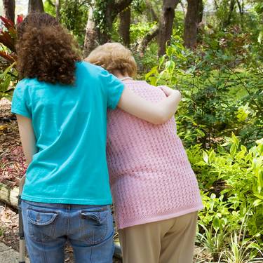Junge Frau hilft einer Seniorin beim gehen