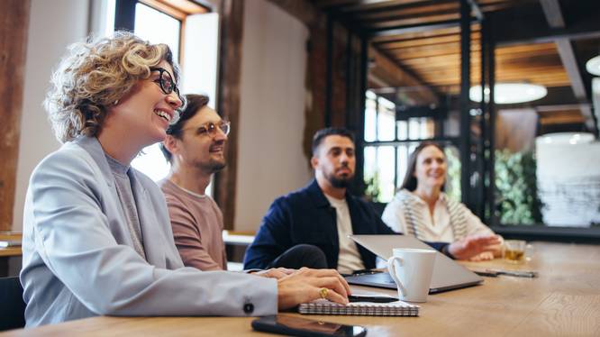 Conference meeting in an office, happy business team sits together in a boardroom