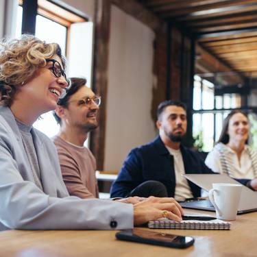 Conference meeting in an office, happy business team sits together in a boardroom