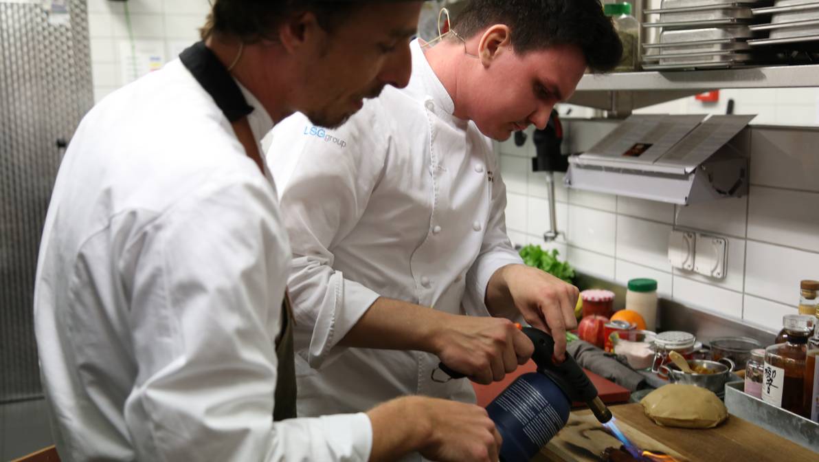 Mario Enchelmaier (l) und Tourismusstudent Jan van Ditzhuijzen (r) in Aktion in der Mensa-Küche der FH Graubünden.