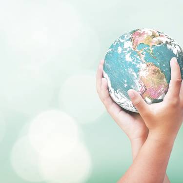 Hände halten eine Weltkugel.