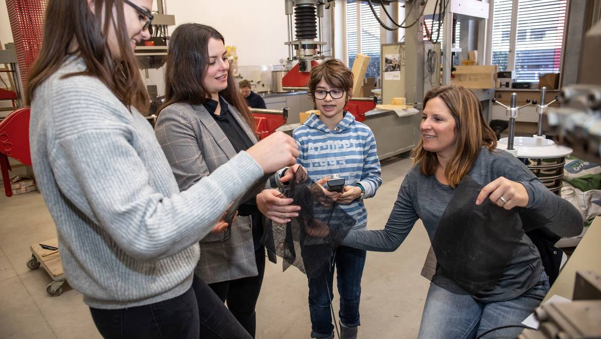 Mentorin Barbara Krummenacher erklärt den Testaufbau des Zugversuchs von Geotextilien im Baulabor der FH Graubünden. 