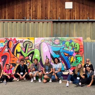 Neustudierende 2021: Englische Klasse des Bachelorstudiums Tourismus vor eigenem Graffiti