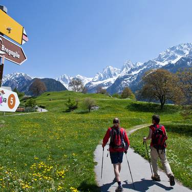 Zwei Männer wandern in Richtung Via Bregaglia inmitten der Bündner Bergwelt.