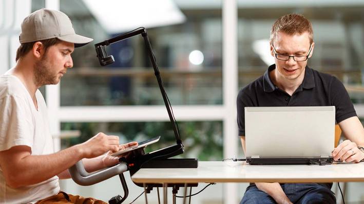 Zwei Personen beim Test des Eyetracking je mit einem Laptop und einem eBook-Reader