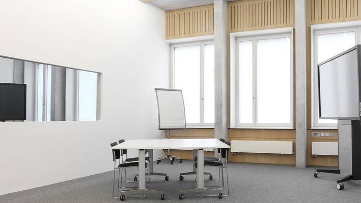 Ein Raum mit einem Arbeitstisch und einem Whiteboard