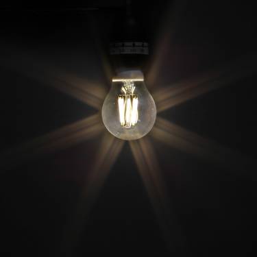 Eine Glühbirne leuchtet in der Dunkelheit