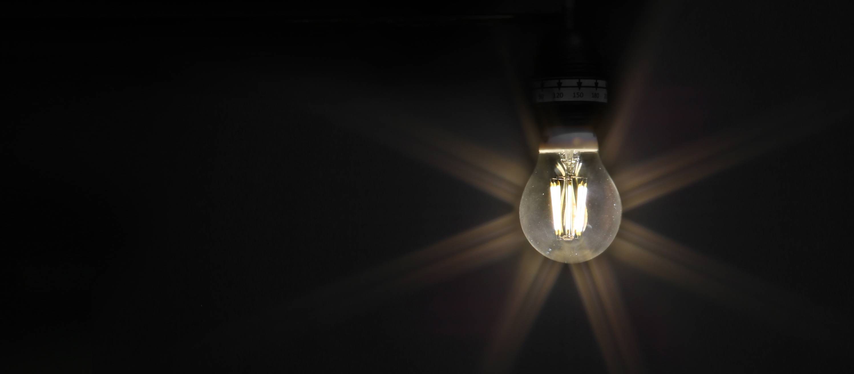 Eine Glühbirne leuchtet in der Dunkelheit