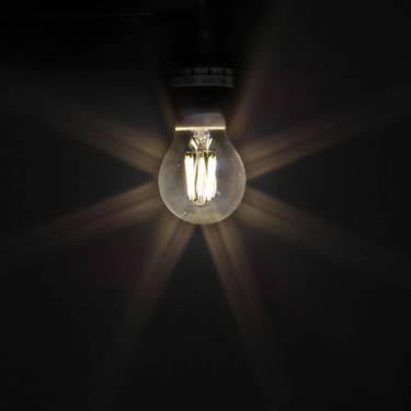 Eine Glühbirne leuchtet in der Dunkelheit