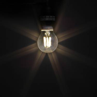 Eine Glühbirne leuchtet in der Dunkelheit