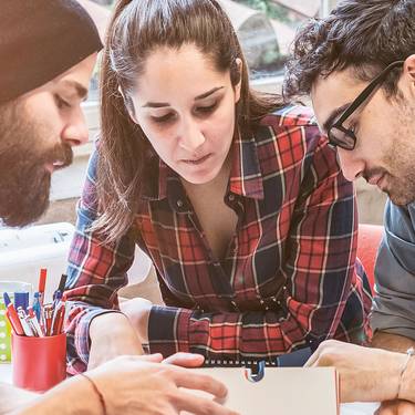 Imagebild Bachelorstudium Tourismus, Studierende sitzen diskutierend an einem Tisch