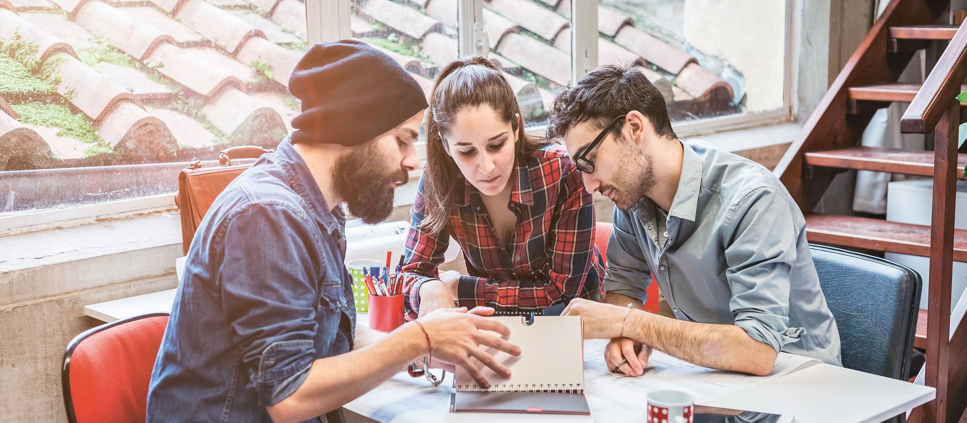 Imagebild Bachelorstudium Tourismus, Studierende sitzen diskutierend an einem Tisch