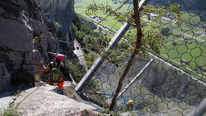 Steinschlagnetz an Felswand – Beispiel für Herausforderungen im Bauingenieurwesen in der Schweiz.