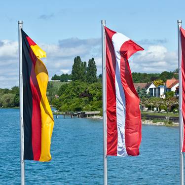 Flags oh European countries flying in front of a blue lake