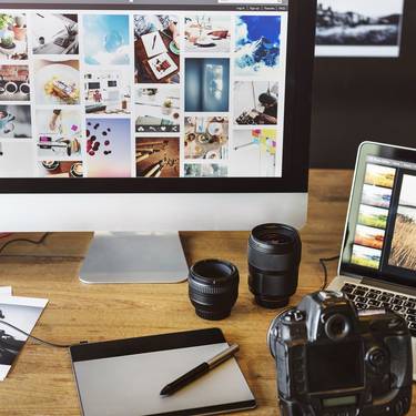 Dektop, Laptop, Kamera, Objektive, Tablet und Fotos auf dem Schreibtisch
