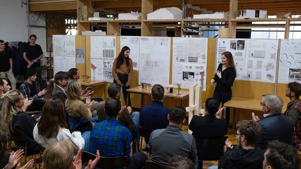 Zwei Architekturstudentinnen der FH Graubünden freuen sich über die Rückmeldungen zu ihrem Entwurf der zukünftigen Bushaltestelle vor dem Fachhochschulzentrum Graubünden. (Bild: FHGR / Barbara Truog)