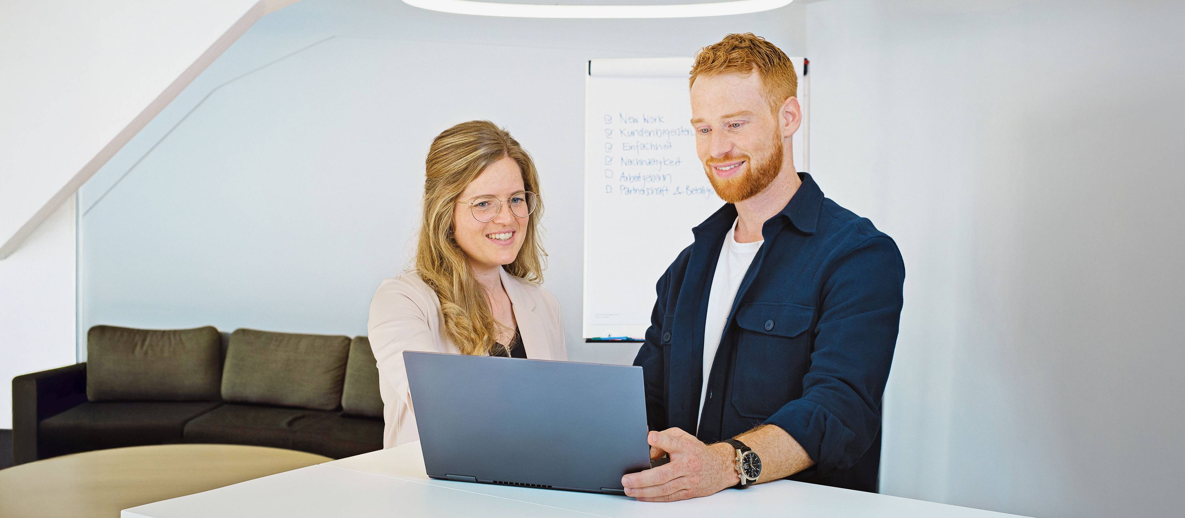 Zwei Studierende arbeiten im Betriebsökonomiestudium am Laptop.