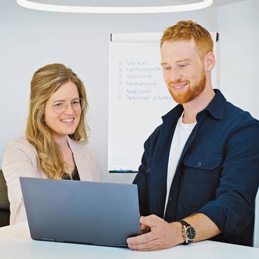 Zwei Studierende arbeiten im Betriebsökonomiestudium am Laptop.