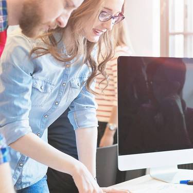Coworkers working on project together in office