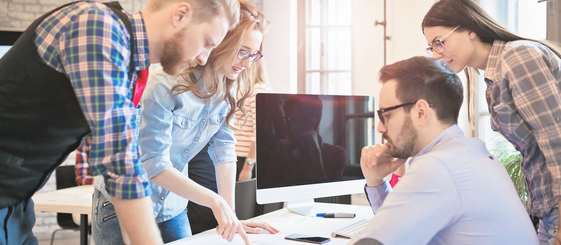 Im Management Studium diskutiert eine Gruppe Studierender eine Praxisarbeit.