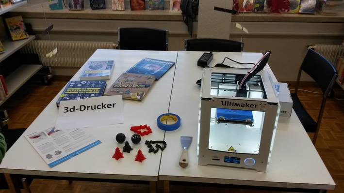 3D-Drucker Tisch mit einem 3D-Drucker sowie Beispiele was damit gedruckt werden kann.
