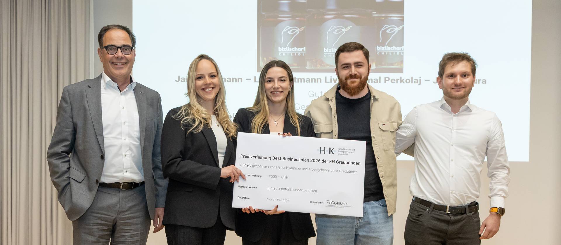 Gewinnen den Best-Businessplan-Wettbewerb 2026 der FH Graubünden, die Betriebsökonomie-Studierenden Jana Gartmann, Jana Tipura, Ermal Perkolaj und Livio Gartmann (v.l.n.r.), mit Preisstifter Andrea Fanzun (ganz links).
