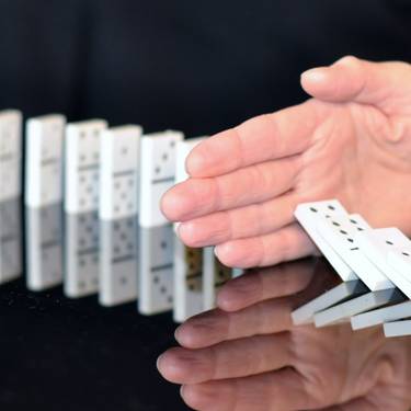 Header, Hand hält umfallende Dominosteine auf