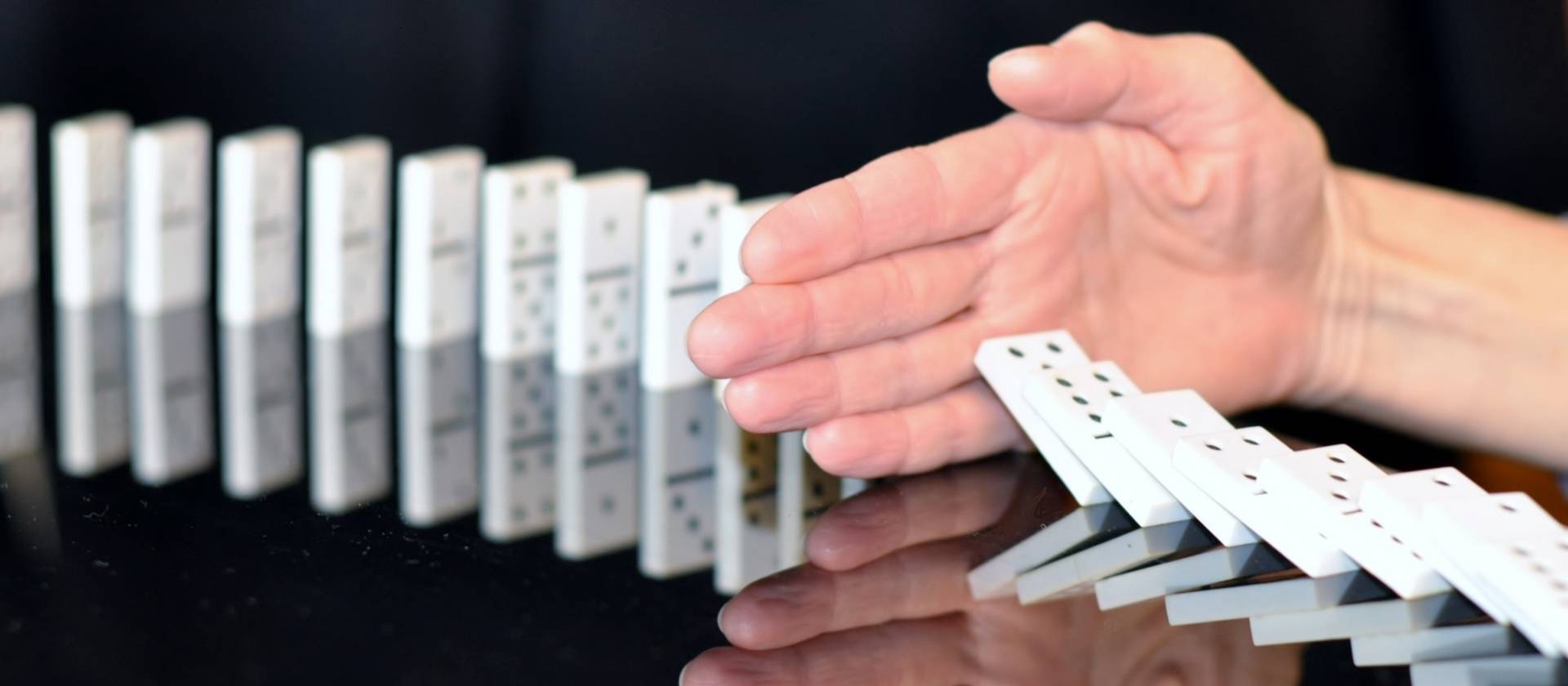 Header, Hand hält umfallende Dominosteine auf