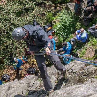 Mann klettert an Felswand