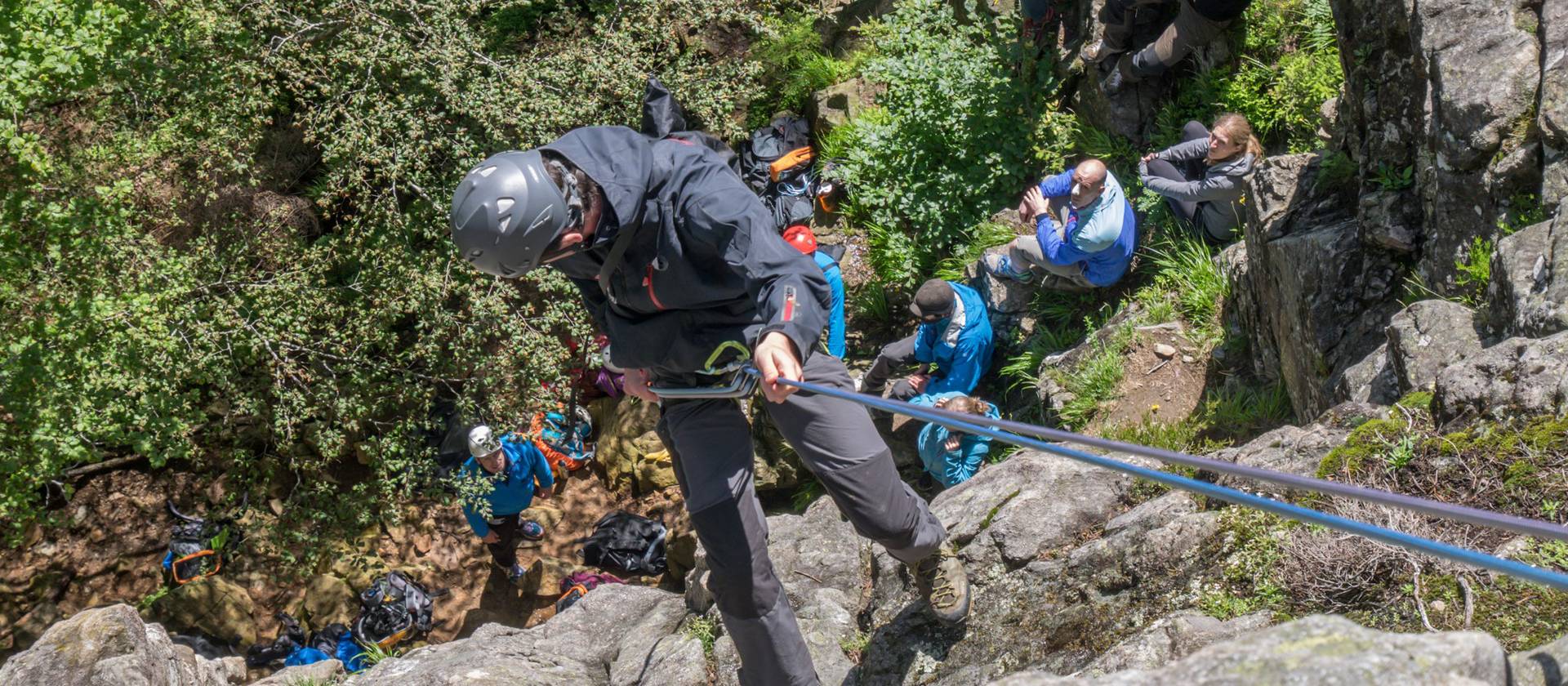Mann klettert an Felswand