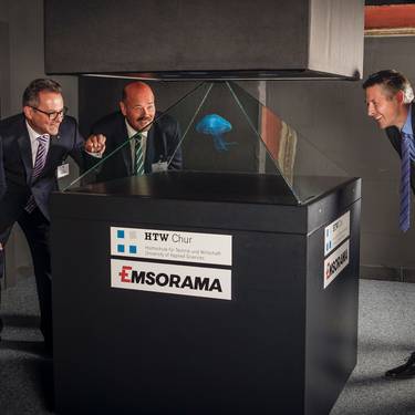 Vier Leute schauen auf ein Quallen-Hologram