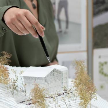 [Translate to Italian:] Architekturstudentin präsentiert ihre Bachelorthesis.