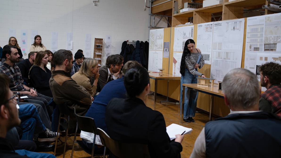 Eine Architekturstudentin der FH Graubünden präsentiert ihren Entwurf zur Gestaltung der zukünftigen Bushaltestelle vor dem Fachhochschulzentrum Graubünden. (Bild: FHGR / Barbara Truog)