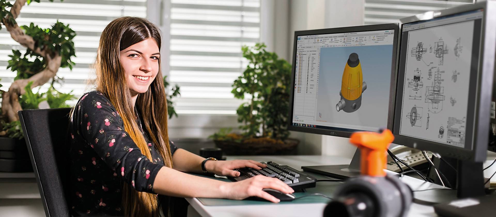 Studentin absolviert duales Studium – hier sitzt sie am Arbeitsplatz am Computer.