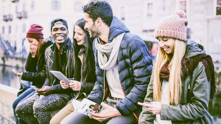 Gruppe von Studierenden lesen eine Infobroschüre der Fachhochschule Graubünden