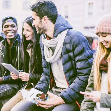 Gruppe von Studierenden lesen eine Infobroschüre der Fachhochschule Graubünden
