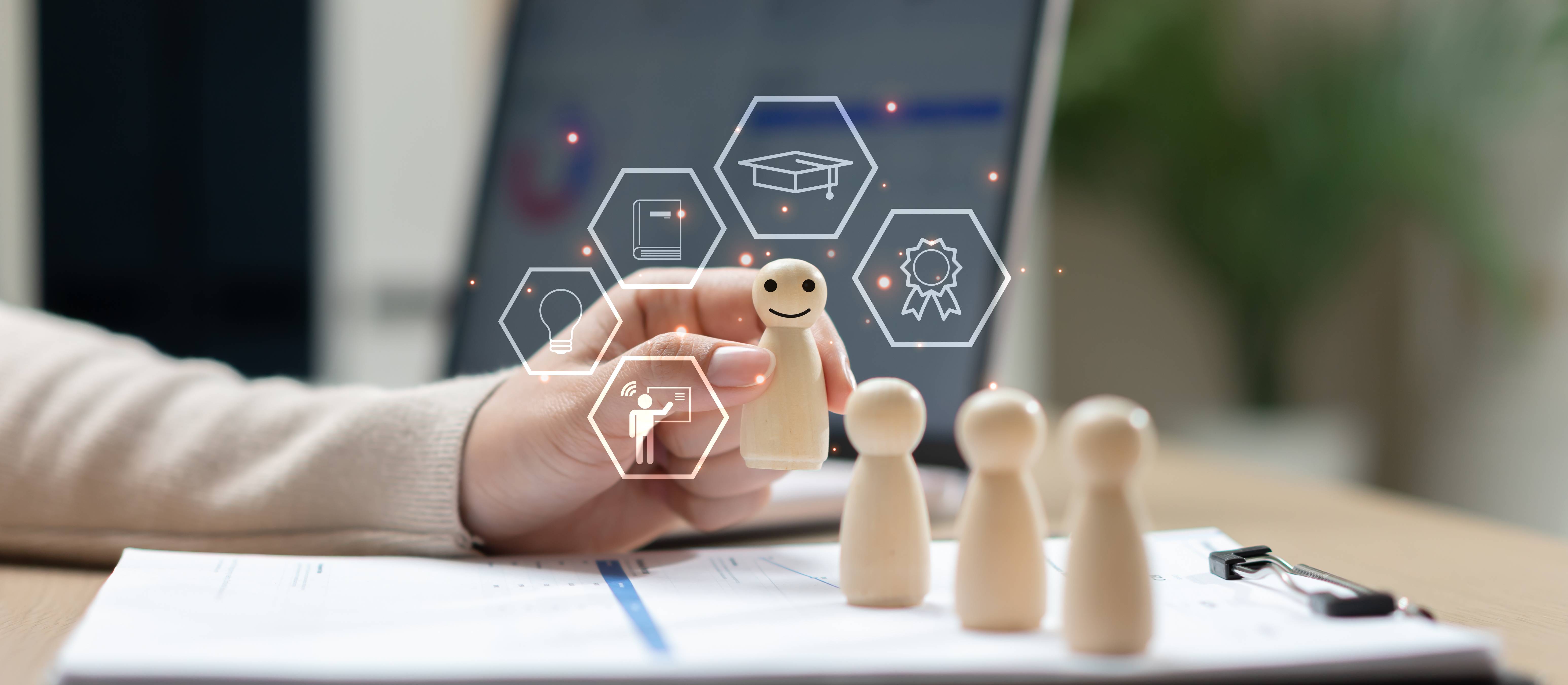 Employee training and professional development concept with wooden figures, digital learning icons and laptop. Workforce education, skill improvement, leadership training and talent management.