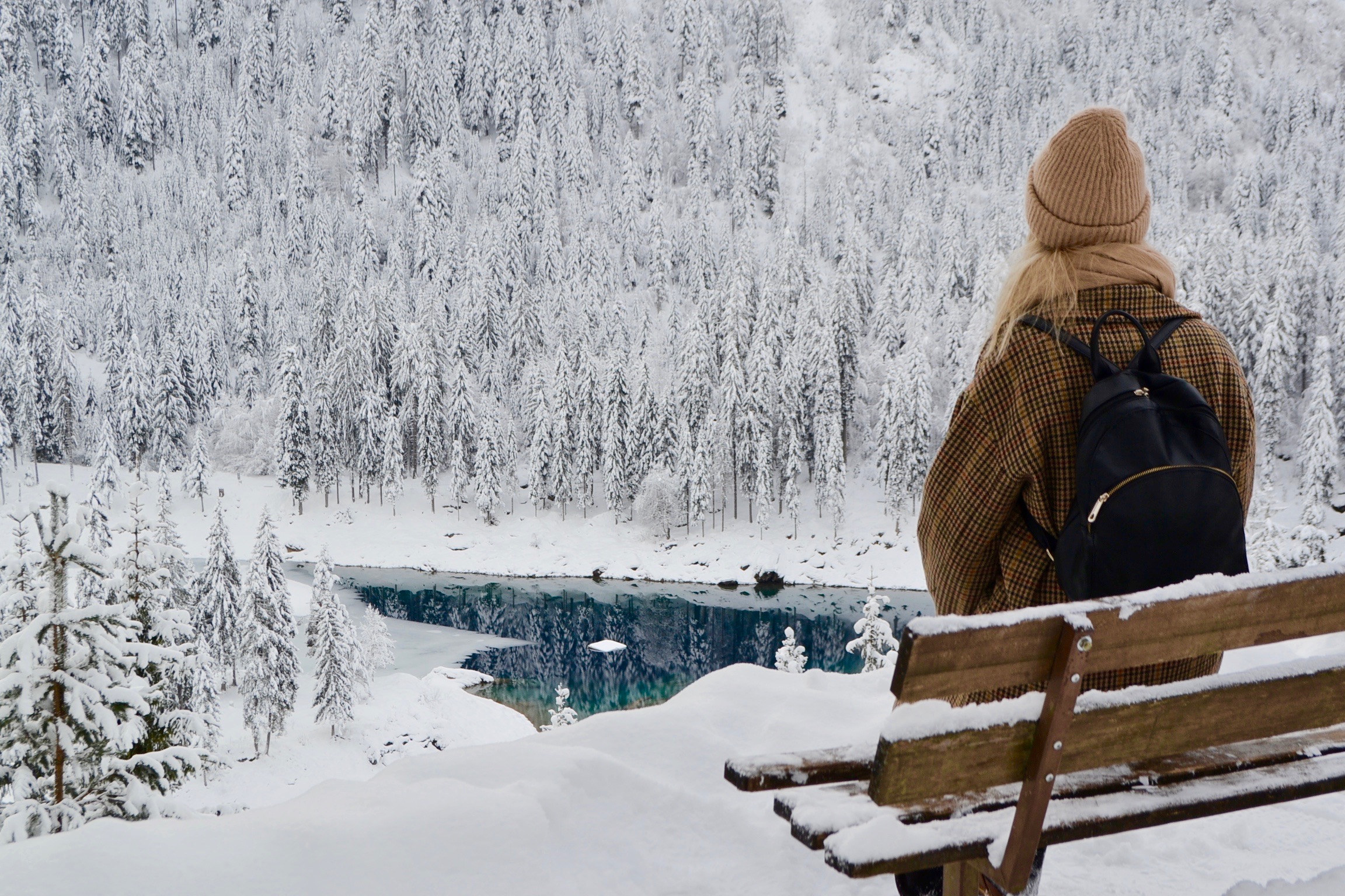Myrthe Schäpkens auf einer Bank in Winterlandschaft